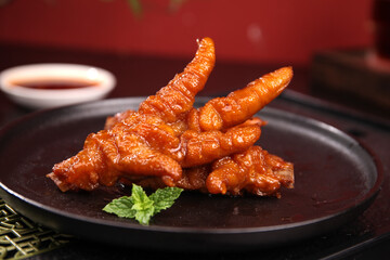 Marinated Chicken Feet Claws Traditional Asian Snack Food with Crispy Skin on Dark Plate