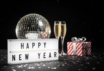 Festive new year celebration with disco ball, champagne, and gift box