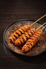 Spicy Grilled Sausage Skewers on Dark Plate with Seasoning - Street Food BBQ Concept