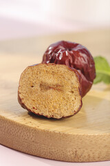 Hami Xinjiang Red Jujube Dates Whole and Sliced Showing Interior on Wooden Board
