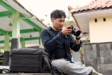 Indonesian photographer preparing and cleaning camera gear outdoors