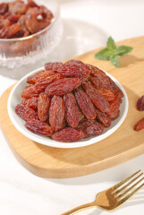 Xinjiang Red Raisins in Bowl - Premium Dried Fruit Snack on Wooden Serving Board