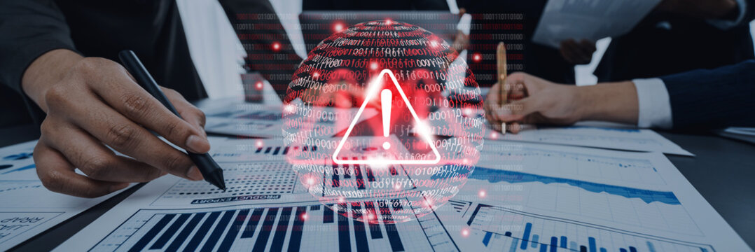 A business team examines critical financial documents with an alert symbol representing risk. Emphasis on teamwork and strategic decision-making in finance. Gantry - Powered by Adobe