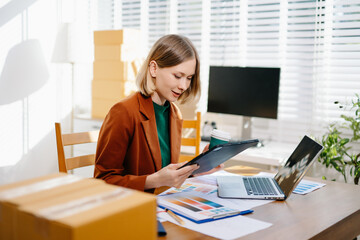Female designer choosing a color palette while working on a creative project in a bright modern workspace.