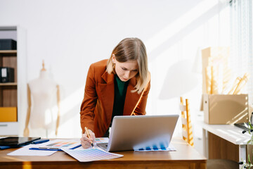 Designer selecting color palette while working on a creative branding project in a modern bright workspace.