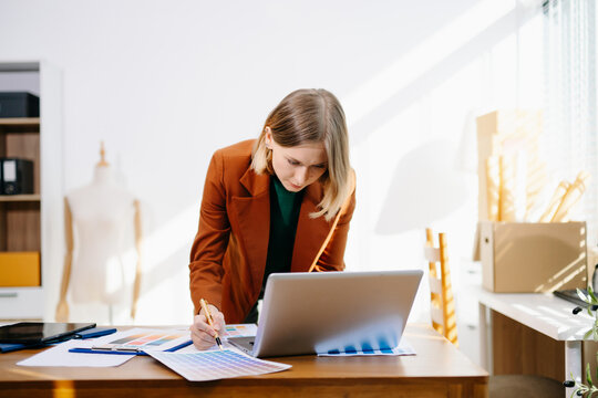 Designer selecting color palette while working on a creative branding project in a modern bright workspace.