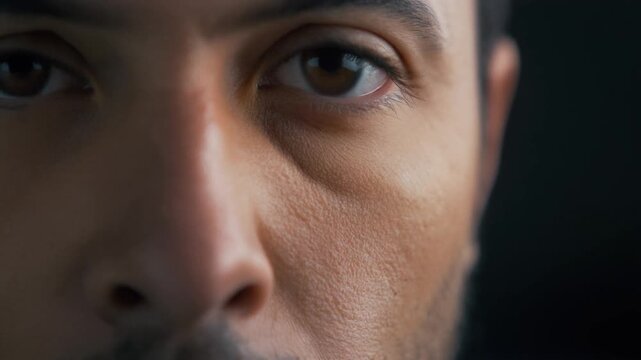 Extreme close-up of a man's face, intense gaze, dramatic lighting, moody atmosphere, close-up portrait, dark background, emotional expression