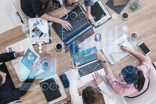 A dynamic overhead view of a business team collaborating with technology tools, displaying data charts and insights for effective decision-making and strategy development. Scalp