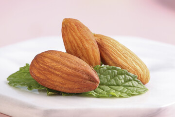 Fresh Almonds with Leaves on White Plate - Healthy Snack
