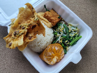 Nasi pecel and sego pecel are typical Javanese Indonesian rice dishes served with pecel sauce, vegetables and others.	