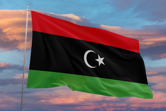 Realistic close-up of the Libya flag waving on a tall flagpole under a bright sky with soft scattered clouds, showing smooth wind motion, vivid colors, and a strong atmosphere of national pride.
