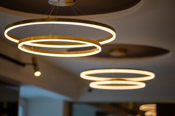 A stunning shot of cascading golden LED ring pendant lamps in a modern interior