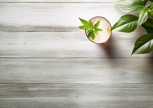 A glass of cocktail and  houseplant on a wooden gray table