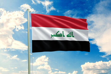 Realistic close-up of the Iraq flag waving on a tall flagpole under a bright sky with soft scattered clouds, showing smooth wind motion, vivid colors, and a clear, proud national atmosphere.
