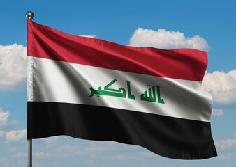 Realistic close-up of the Iraq flag waving on a tall flagpole under a bright sky with soft scattered clouds, showing smooth wind motion, vivid colors, and a clear, proud national atmosphere.
