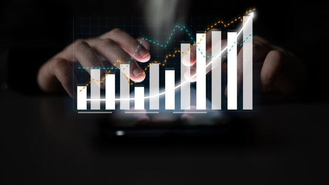 A close-up view of hands engaging with digital financial graphs and charts on a smartphone, illustrating growth and data analysis in a modern business environment. Impute