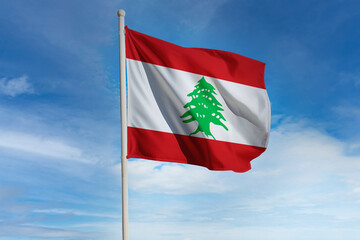 Realistic close-up of the Lebanon flag waving on a tall flagpole under a bright sky with soft scattered clouds, showing smooth wind motion, vivid colors, and a clear atmosphere of national pride.
