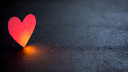 adoration. A red heart symbol stands out against a textured black background with a warm glow. wellbeing guides, coaching materials, designed for coaching and self-improvement content.