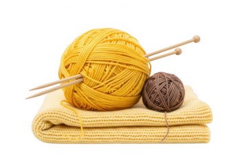 A large yellow yarn ball with wooden knitting needles, a small brown yarn, and a cozy folded knitted fabric.
