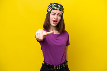 Young Ukrainian woman isolated on yellow background frustrated and pointing to the front