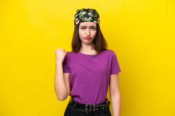 Young Ukrainian woman isolated on yellow background with unhappy expression