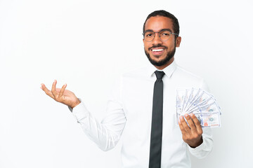 Young business latin man taking a lot of money isolated on white background extending hands to the...