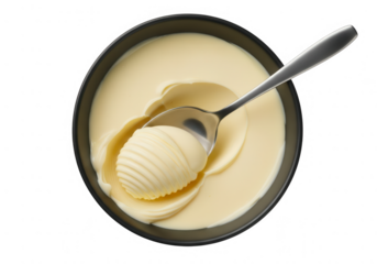 Top view of a metal spoon scooping a perfectly formed curl of creamy, yellow butter from a black bowl, ready for cooking or baking.