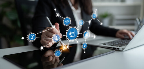 A focused business professional engages with a digital tablet in a modern workspace, illustrating...