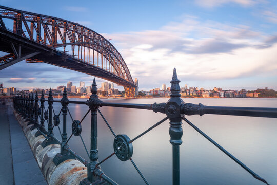 Die Sydney Harbour Bridge und Wolkenkratzer des CBD im Abendlicht. Blick von Kirribilli auf Sydneys Central Business District bei D&auml;mmerung.