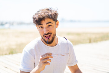 Handsome Arab man at outdoors With glasses with happy expression