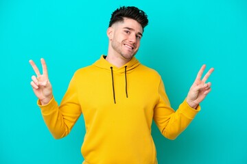 Fototapeta premium Young caucasian man isolated on blue background showing victory sign with both hands