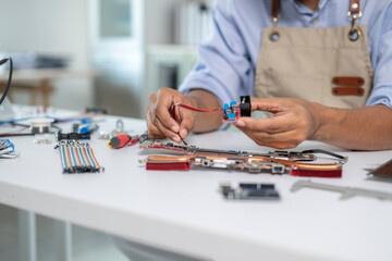 Technician repairing motherboard, connecting components with cables