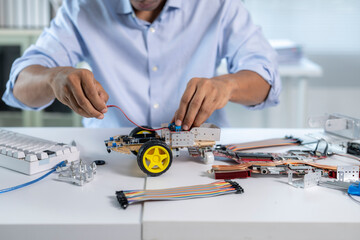 Engineer connecting wires to a robot prototype in laboratory