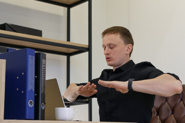 Businessman gesturing stop with outstretched hands in office setting