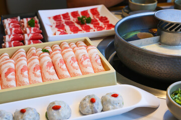 Spicy Mala hot pot with sliced meat on dining table ready to serve.
