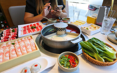 Spicy Mala hot pot with sliced meat on dining table ready to serve.
