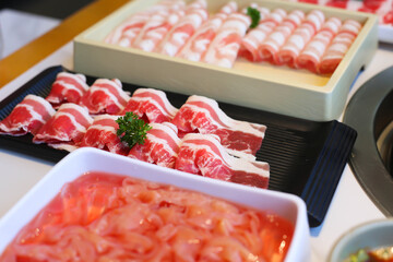 Spicy Mala hot pot with sliced meat on dining table ready to serve.

