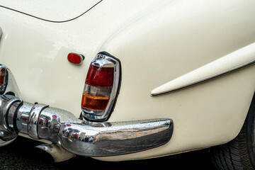 vintage auto element of a white old automobile car in retro style. headlight of a vintage car close up