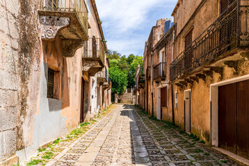 old narrow italian street in traditional mediterranean style with yellow stone walls and beautiful windows. Amazing antuque buildings on a old inalian street.