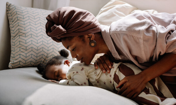 Mother gently embracing her sleeping baby