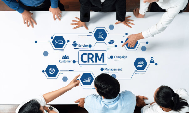 A dynamic scene capturing hands of professionals pointing at a CRM diagram on a white table, symbolizing teamwork and strategy in customer relationship management and service improvement. Amity - Powered by Adobe
