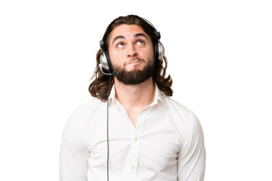Telemarketer man working with a headset over isolated chroma key background and looking up