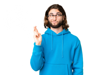 Young handsome man over isolated chroma key background with fingers crossing and wishing the best