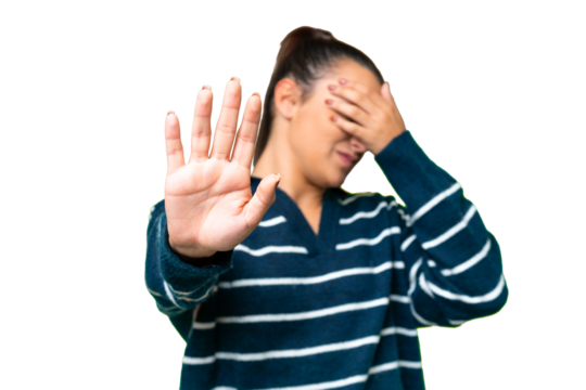 Young beauty woman over isolated chroma key background making stop gesture and covering face