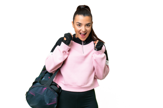 Young sport woman with sport bag over isolated chroma key background celebrating a victory in winner position