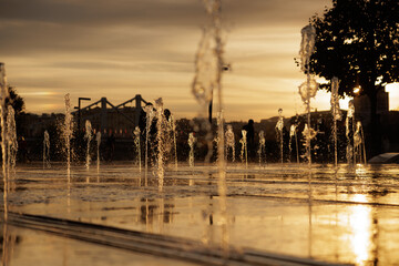 Relaxing evening at the fountain with golden sunset reflecting off the water