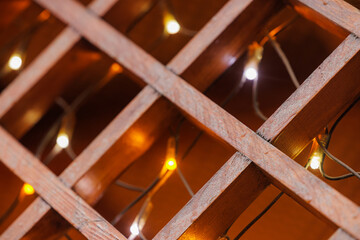 Warm glow of decorative lights shining through wooden lattice during cozy evening ambiance