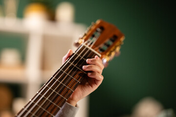 Hand playing chords on classical guitar neck