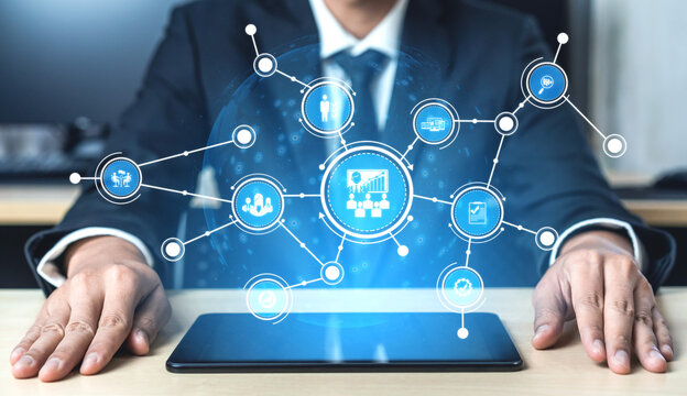 Businessman interacting with a digital interface showcasing data visualization above a tablet, representing the intersection of technology and business analytics in a modern office setting. Tessel