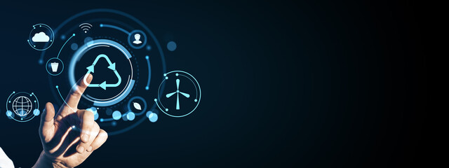 Hand touching digital recycle icon with futuristic eco and cloud symbols on dark background, representing sustainability and technology concept.